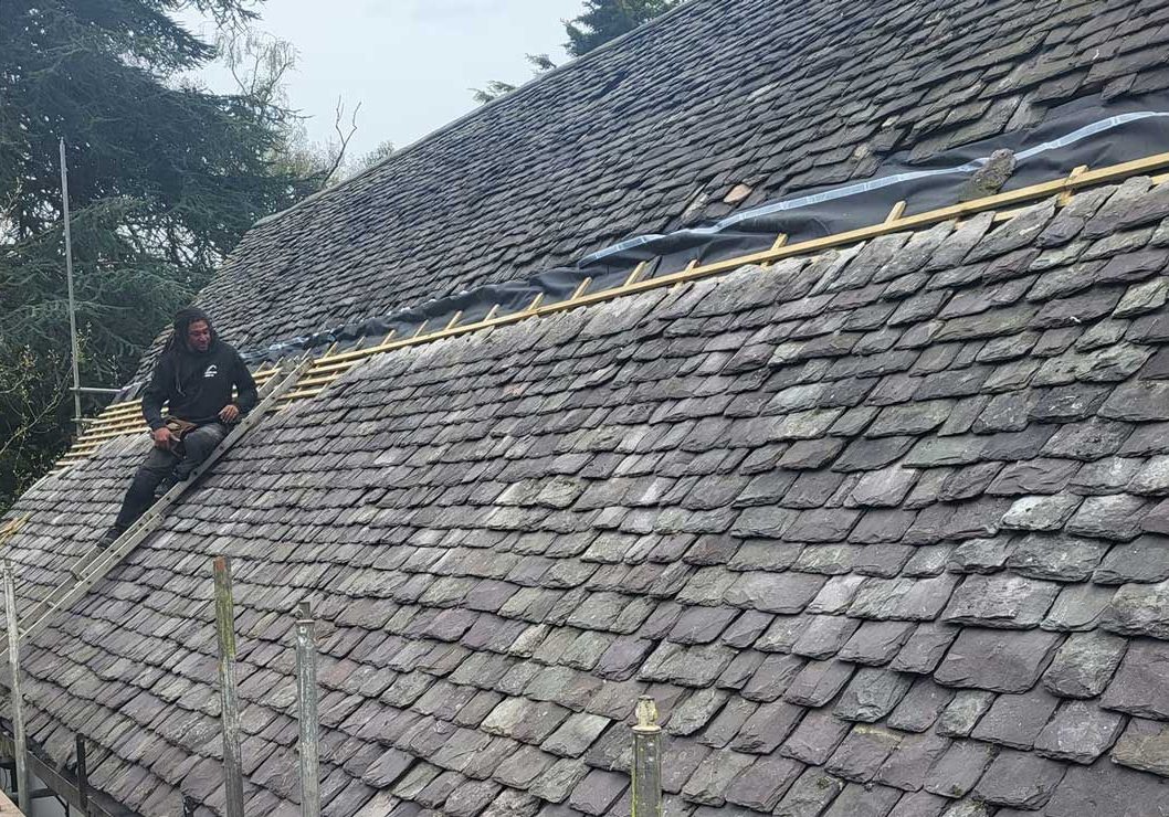 Man fixing old style tile roof
